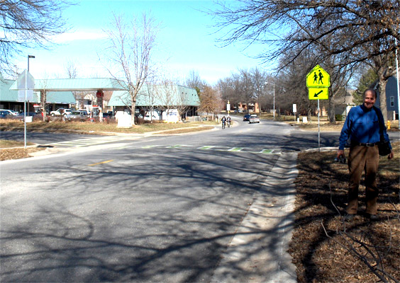 photo shows an intersection with a crosswalk across a street with two wide lanes